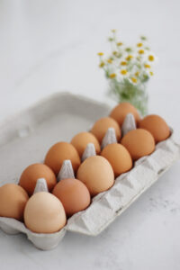 egg carton next to scrambled french eggs